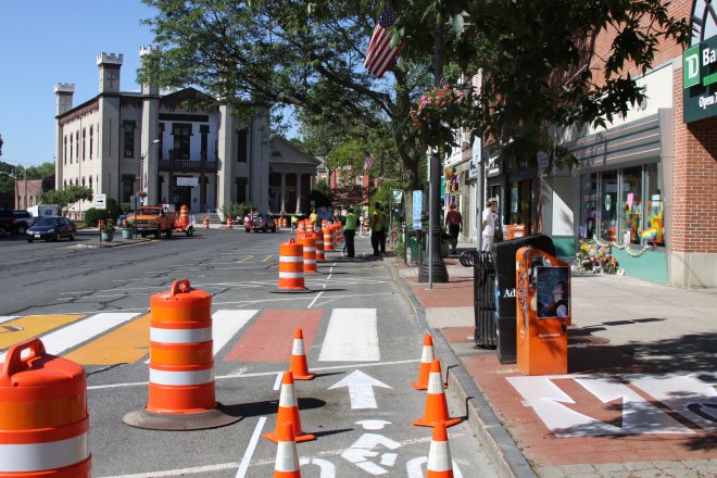 Main Street Northampton showing complete streets demonstration day in process of being set up. Shows separated bicycle lane with City Hall in background.